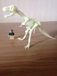dinosaur skeleton about to eat up archaeologist lego man 